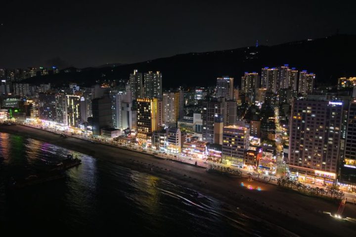 A stunning nighttime view of Busan's illuminated skyline and coastline in South Korea.