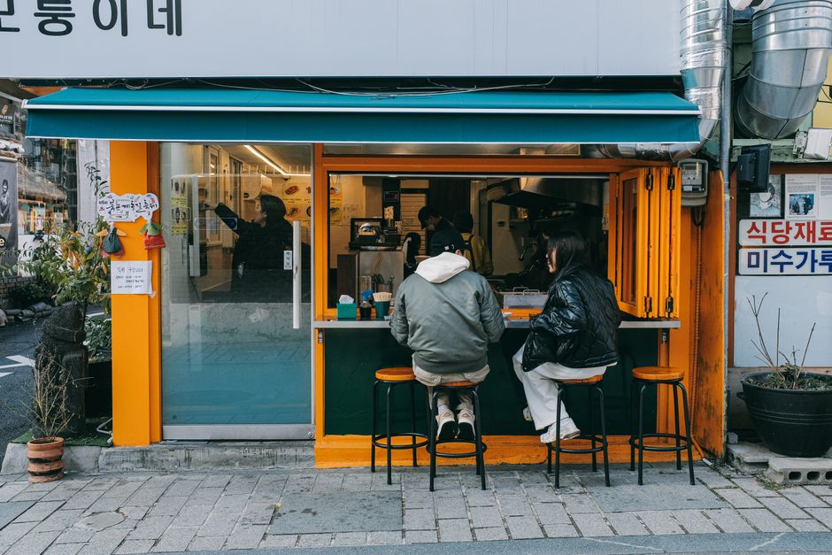 A couple sitting at a cozy street café in Seoul, South Korea, enjoying the urban atmosphere.