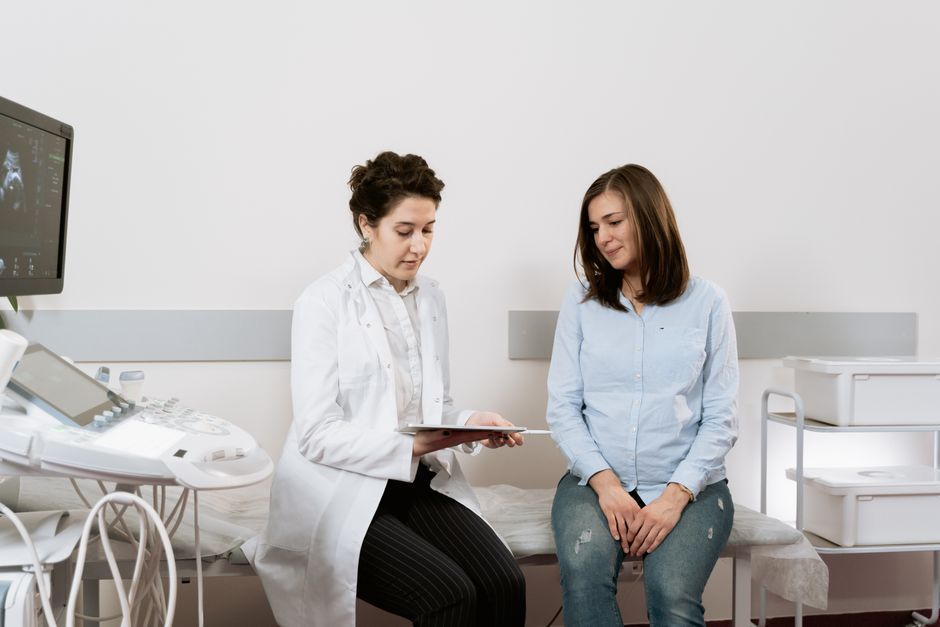 A pregnant woman consulting with a gynecologist in a medical facility.
